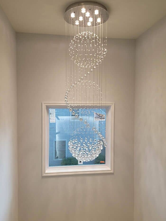 Chandelier with spherical glass orbs and hanging crystals in a minimalist interior.