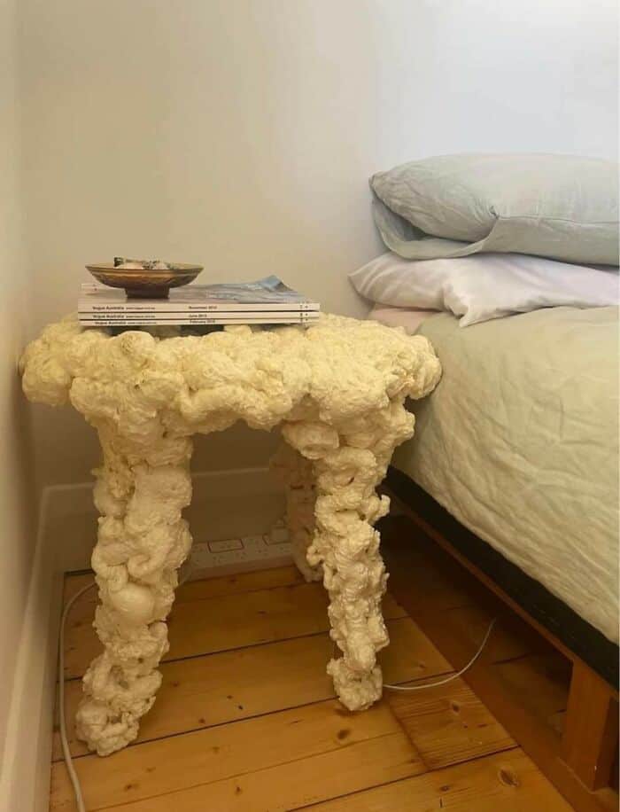 Unique cloud-shaped bedside table made of fluffy, textured material in a bedroom setting.