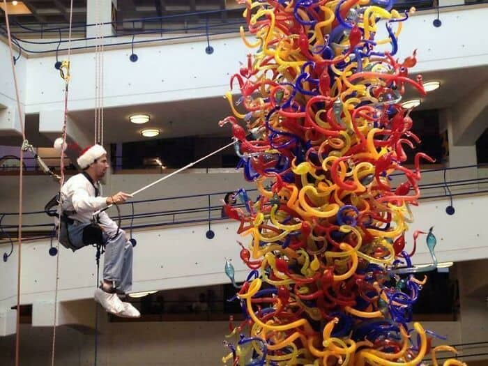 Vibrant glass sculpture with swirling red, yellow, blue, and orange glass pieces at Pleated Jeans ar.