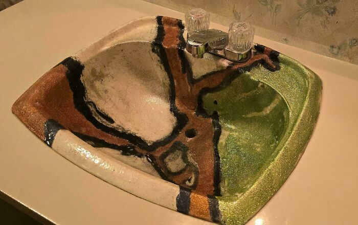 Vintage ceramic sink with colorful abstract pattern and chrome faucet.