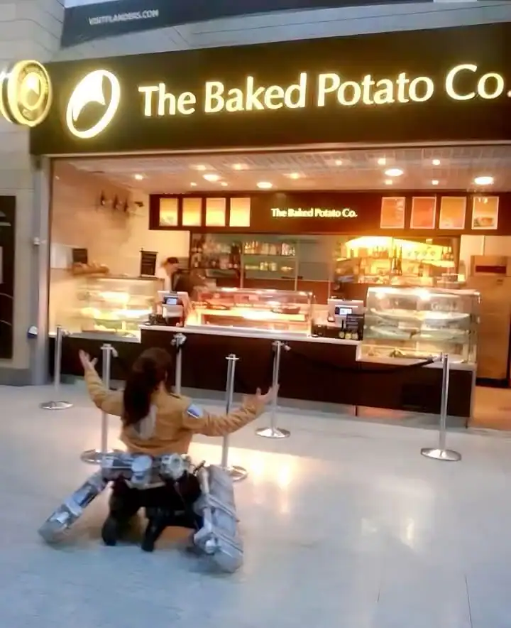 The Baked Potato Co. storefront with a customer sitting on a luggage cart in front.