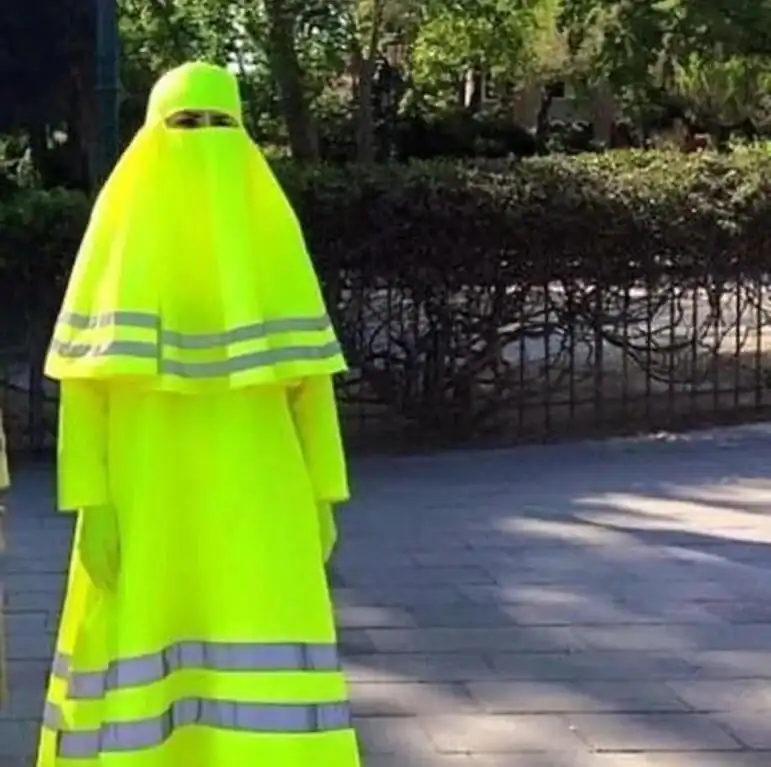 High-visibility yellow safety vest with reflective stripes, draped over a mannequin outdoors.