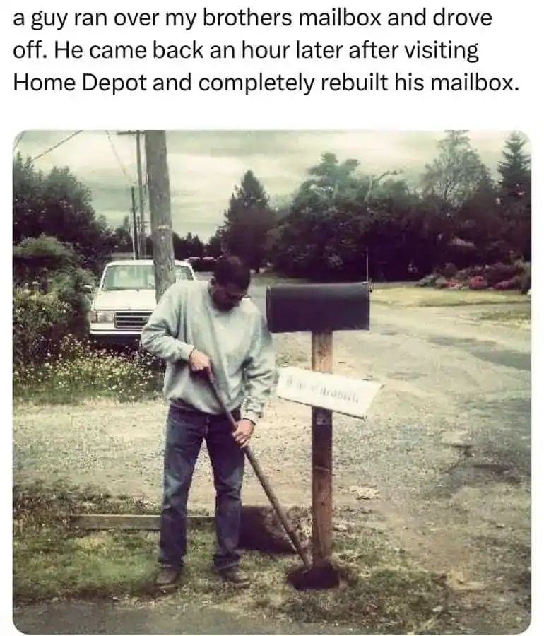 Man repairing a mailbox after it was knocked over, using a shovel in a rural setting with trees and.
