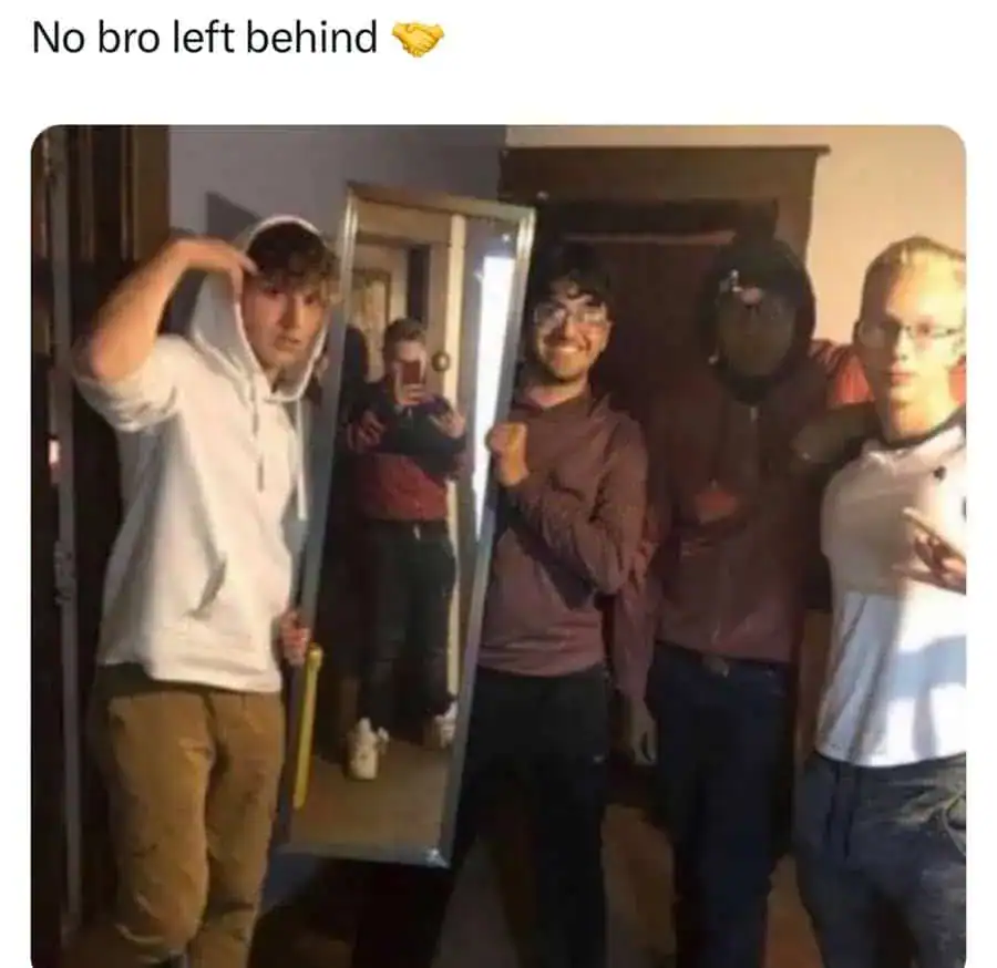 Group of friends at a party, with one person holding a mirror, smiling and posing.
