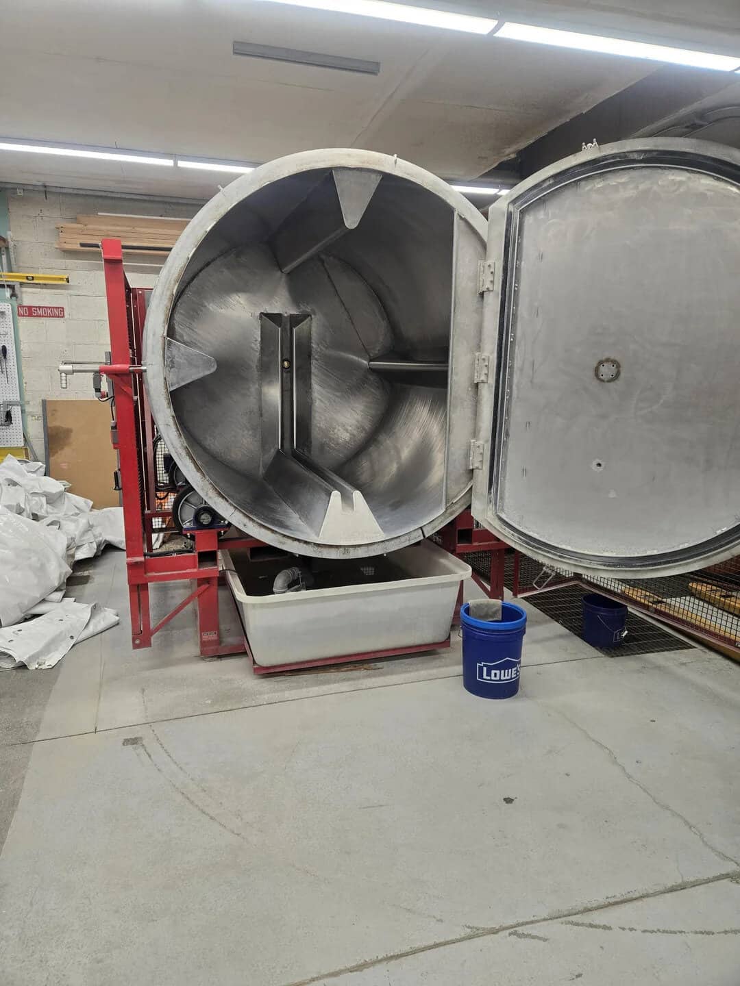Large industrial oven with open door in a workshop setting.