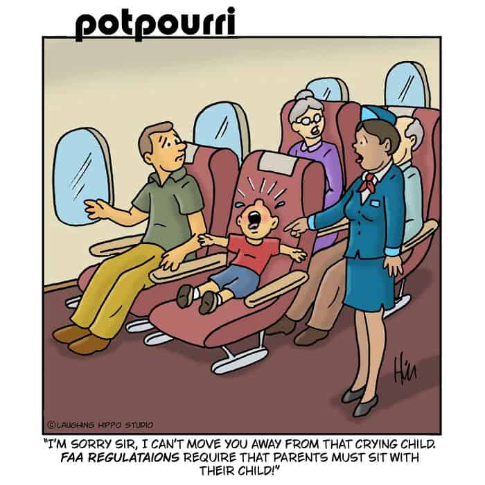 An airplane cabin with a crying child and flight attendants attending to him.