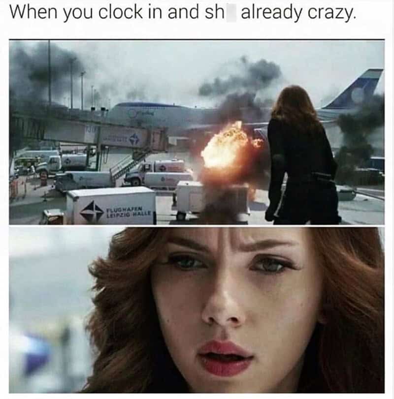 Woman looks shocked at airport with burning plane in background.