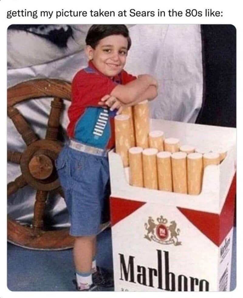 Child smiling with a box of Marlboro cigarettes in the 80s.