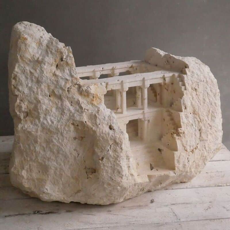 Miniature marble architectural model embedded in a large rock, titled 'classical-architecture-sculpt.