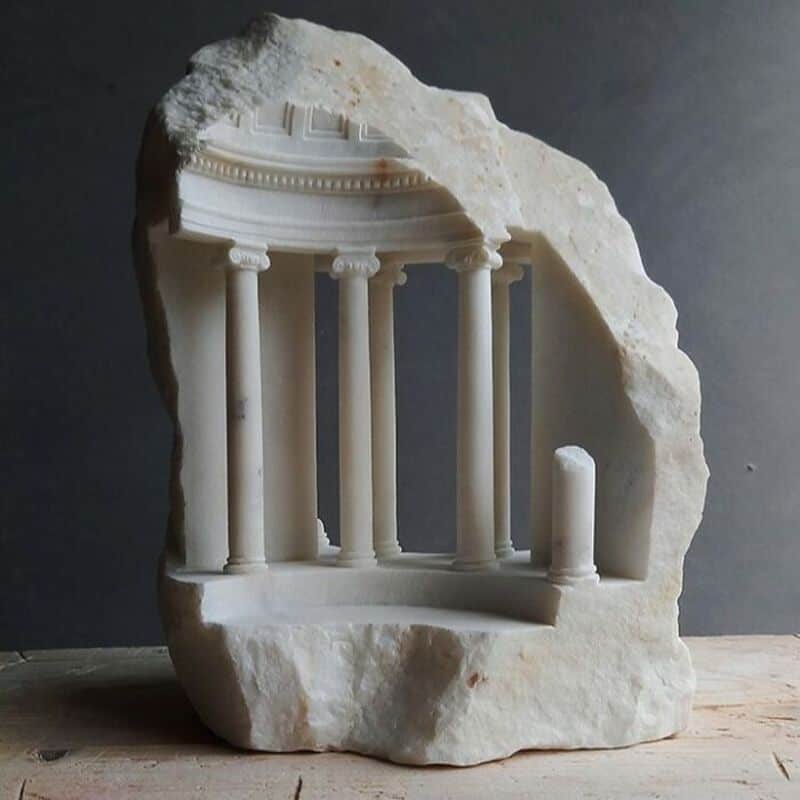 Ancient marble sculpture fragment of classical architecture with columns and entablature.