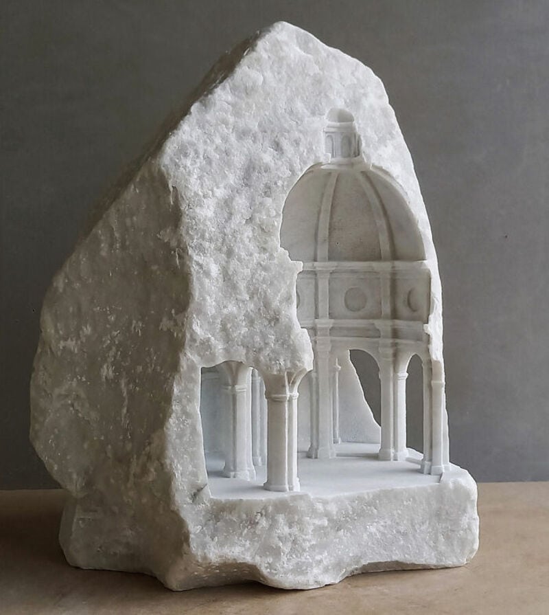 Marble sculpture of a classical temple with a dome, carved into a rough stone block.
