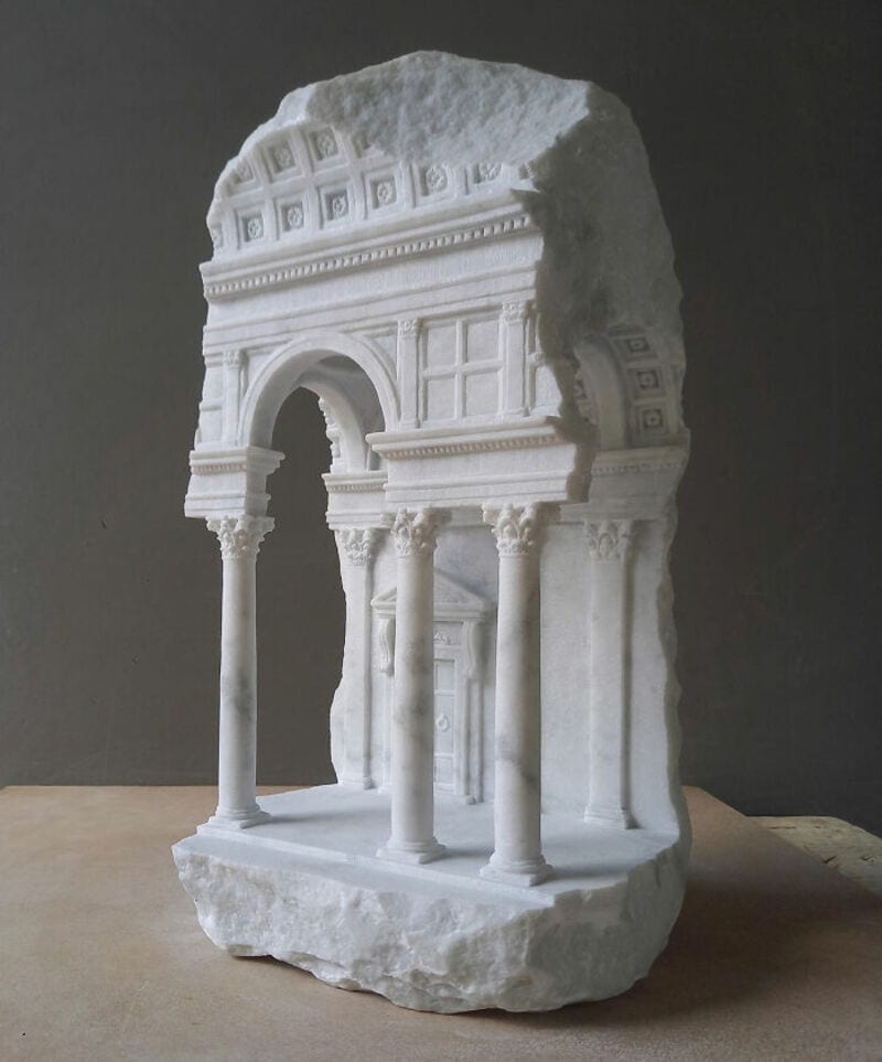Ancient marble sculpture fragment of classical architecture with columns and arches.