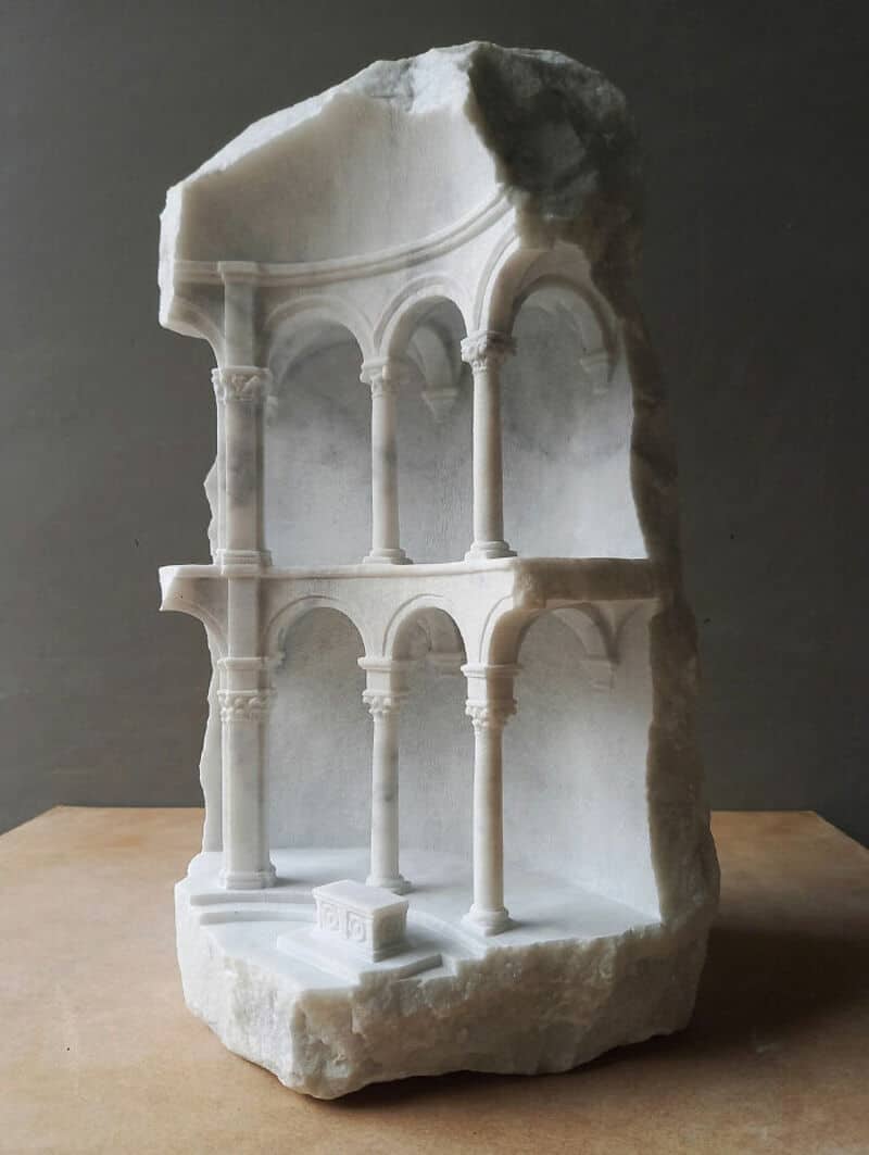 Ancient marble sculpture fragment with arches and columns from classical architecture.