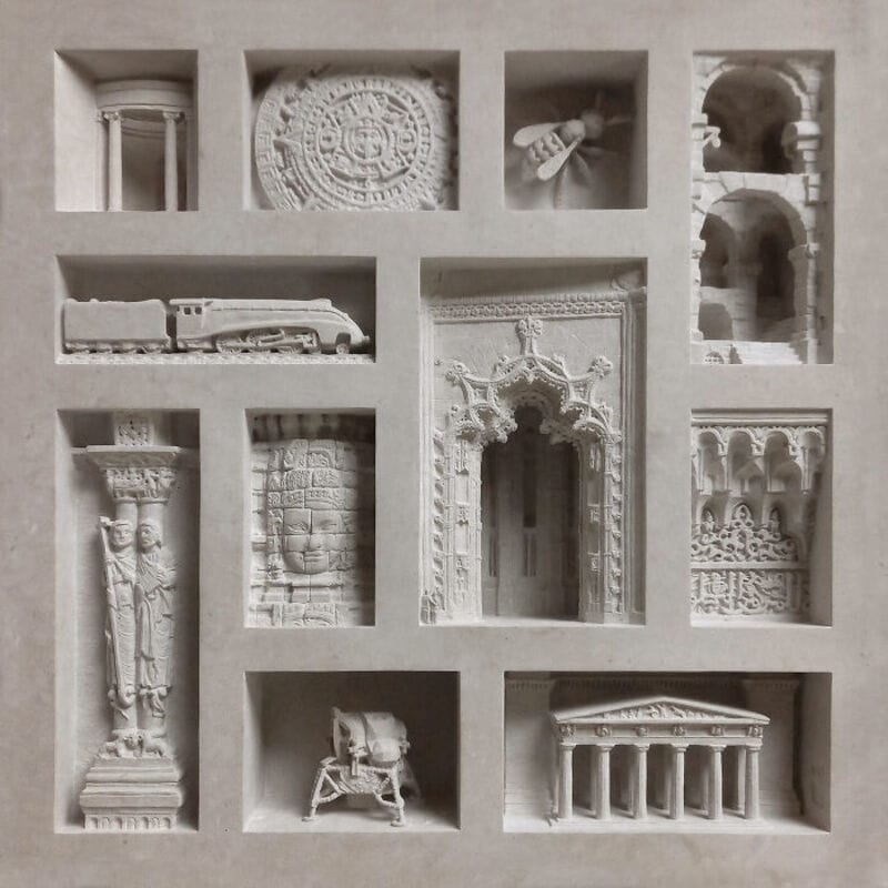 Collection of miniature classical sculptures and architectural elements in a display case.