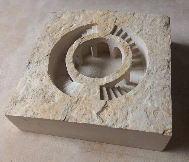Marble sculpture with circular design and stepped inner structure.