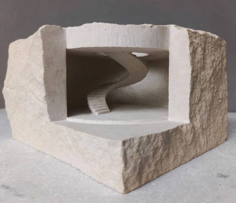 Miniature marble sculpture of a spiral staircase inside a stone block.