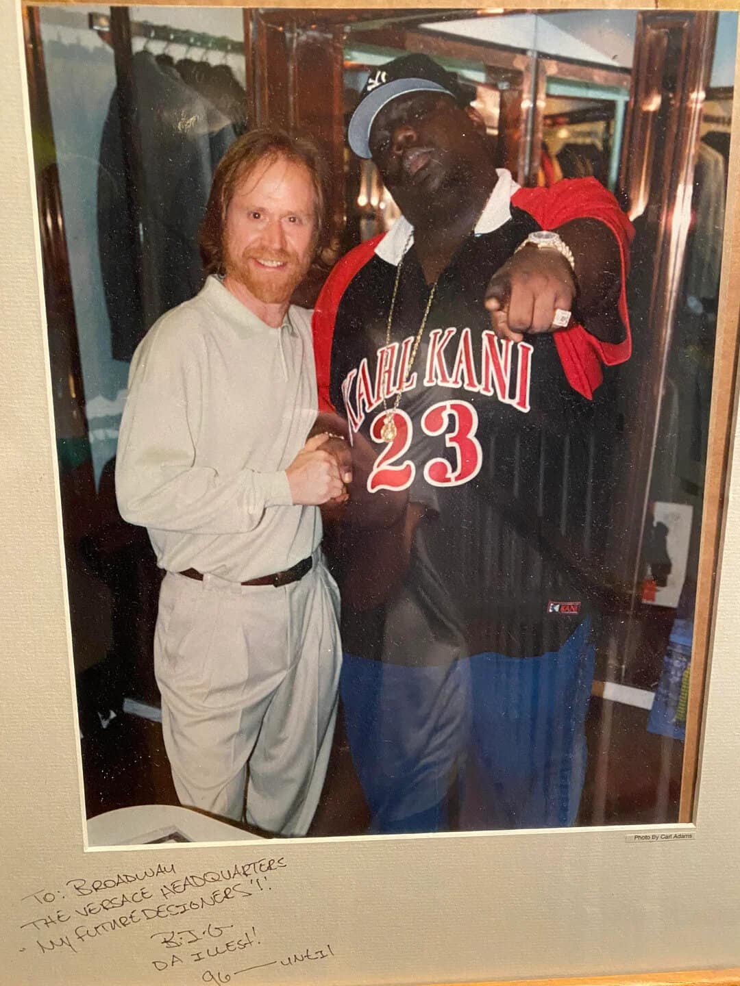 Two men, one with red hair and beard, the other with dark skin and glasses, pose together.
