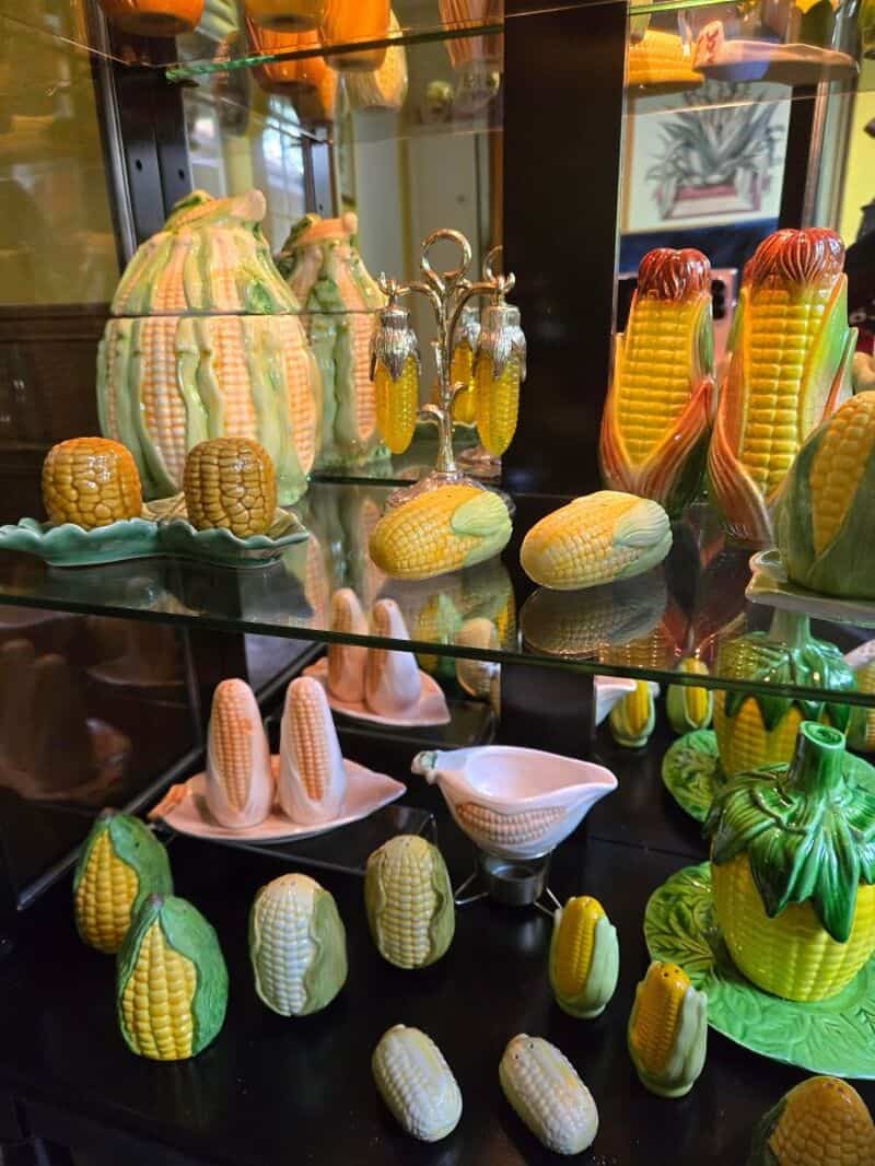 Colorful ceramic corn and pumpkin collection on display shelf.