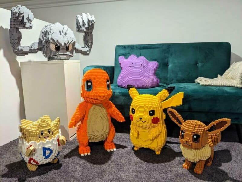 Collection of pixel art Pokémon and a ghost figure made from LEGO bricks in a living room.