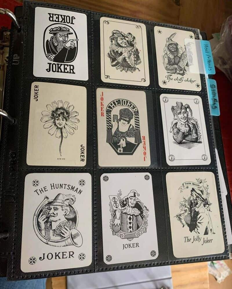 Collection of vintage Joker and tarot cards in a black card binder.