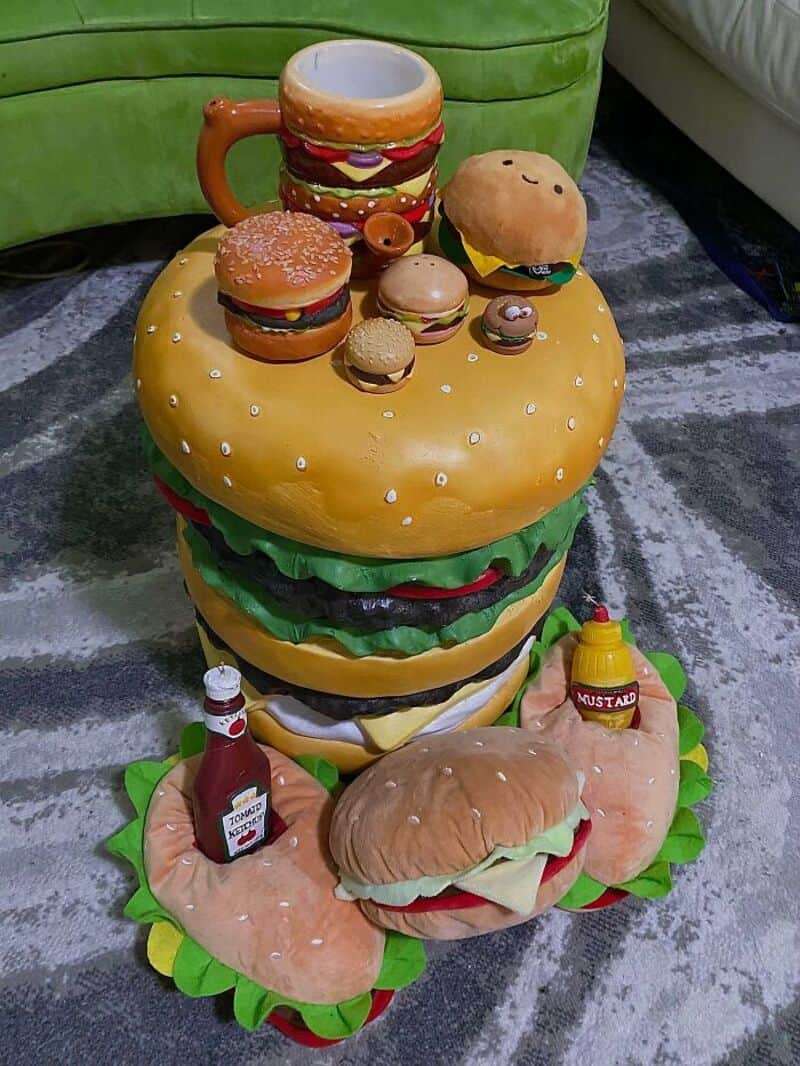 Colorful collection of burger and hot dog toys on a yellow cushion with condiments.