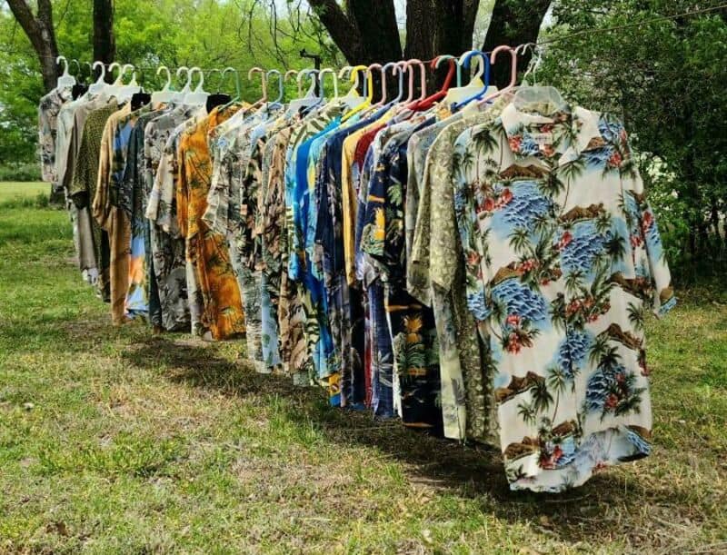 Hawaiian shirts hanging on a line outdoors in a park.
