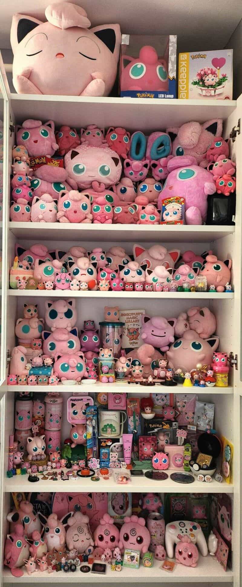 Collection of pink plush toys, including Jigglypuff and other characters, on shelves.