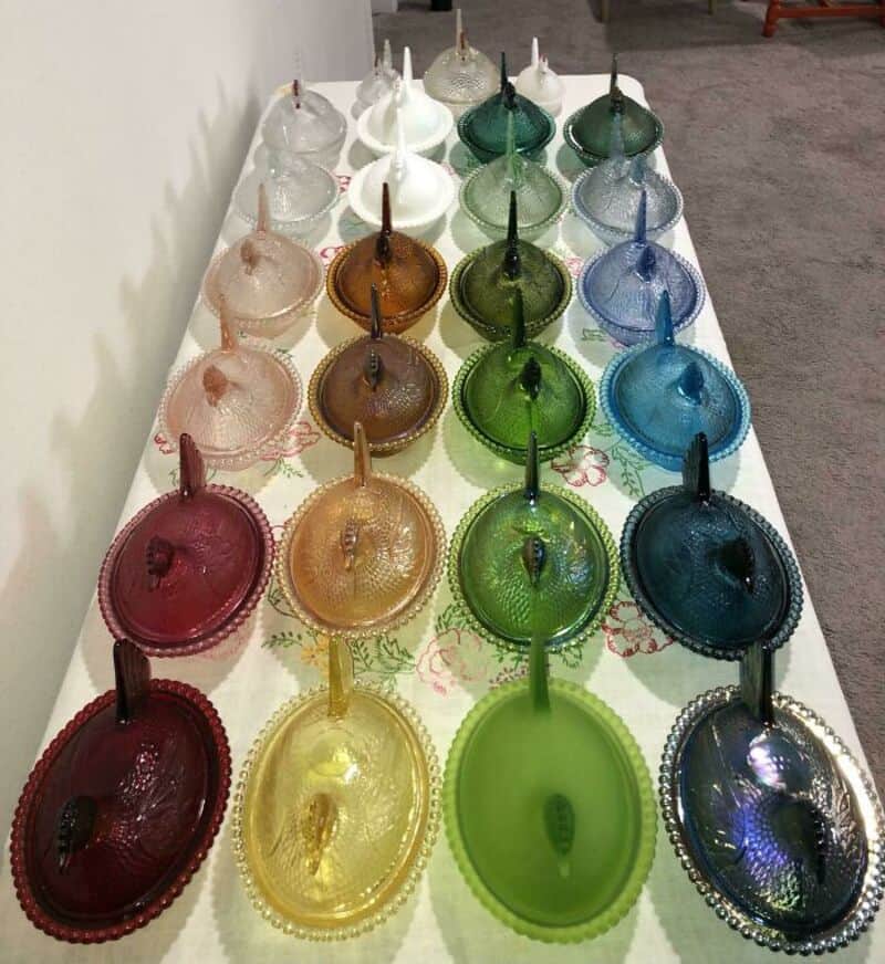Colorful glass lamps arranged on a table in a rainbow pattern.