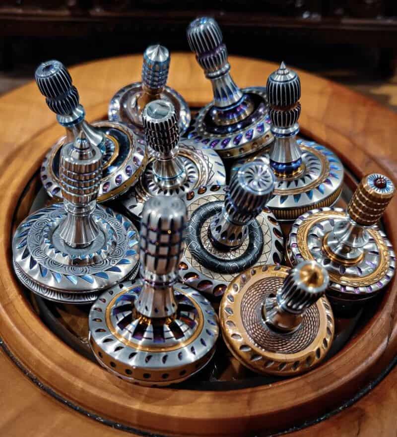 Collection of decorative metal chess pieces on a wooden tray.