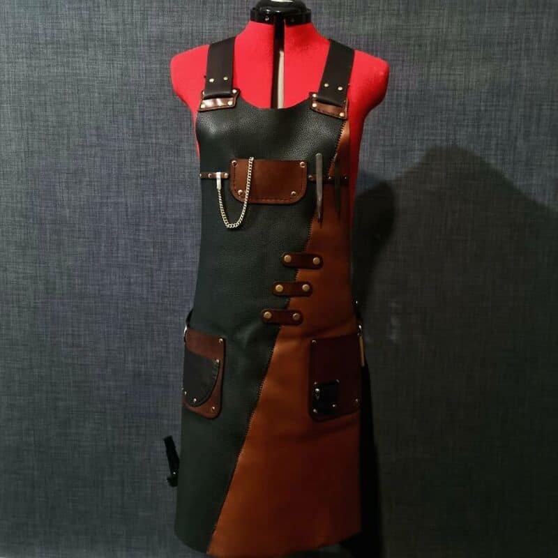 Apron with black and brown leather details, straps, and pockets on a mannequin.