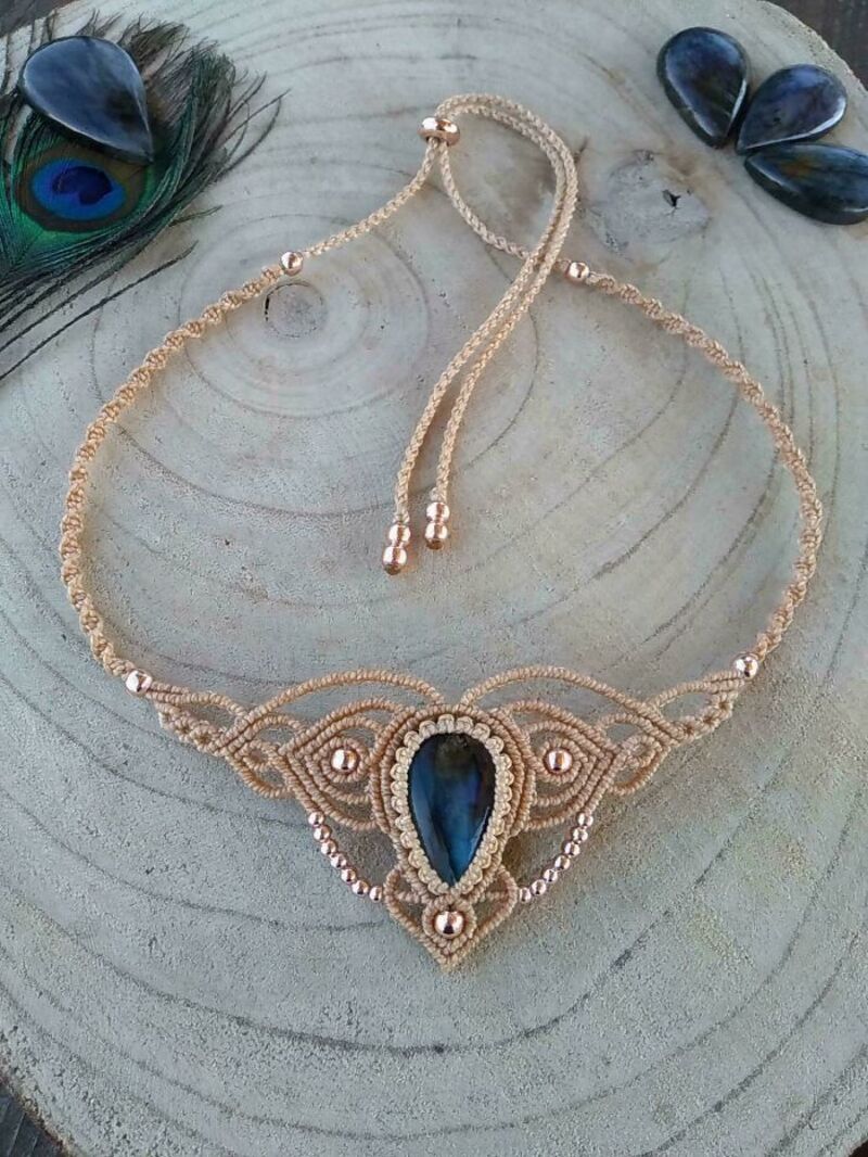 Elegant gold necklace with blue gemstone and pearl accents on wooden surface.