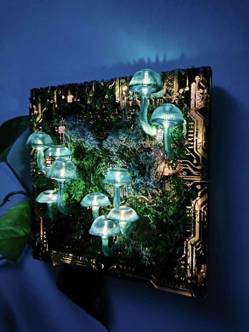 Glowing mushroom art installation with circuit board background and greenery.