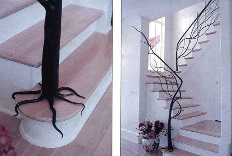 Unique staircase with a tree-like black metal railing and tentacle-like handrail.