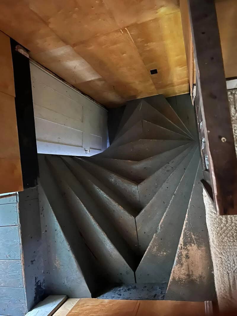Unique black spiral staircase with geometric design in a modern interior.