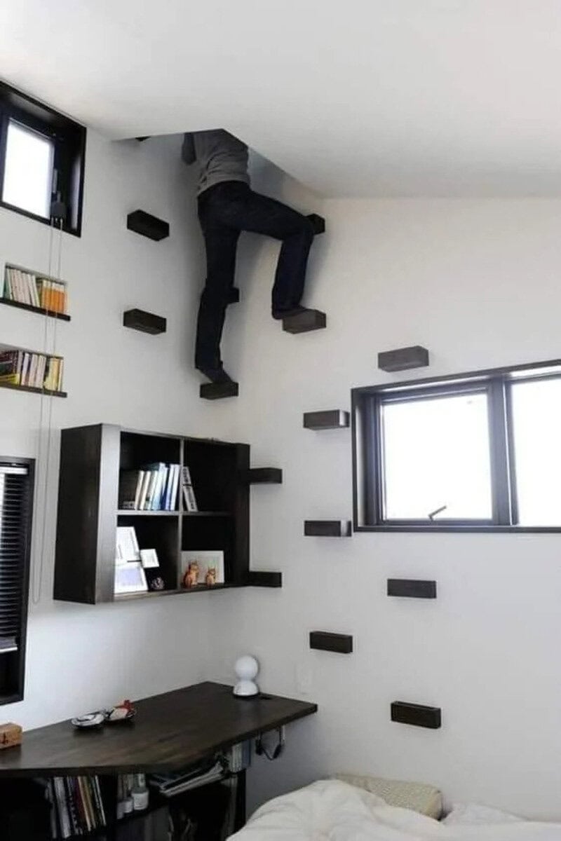 Person climbing on floating shelves on a white wall in a room.