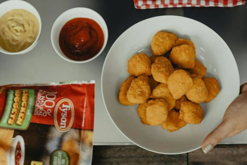 Plate of chicken nuggets with ketchup and mustard on the side.