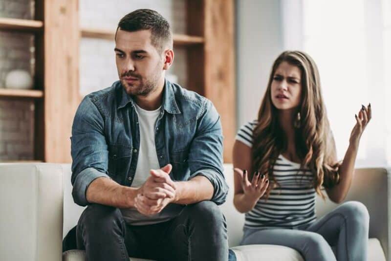 A man and woman having a serious argument in a living room.