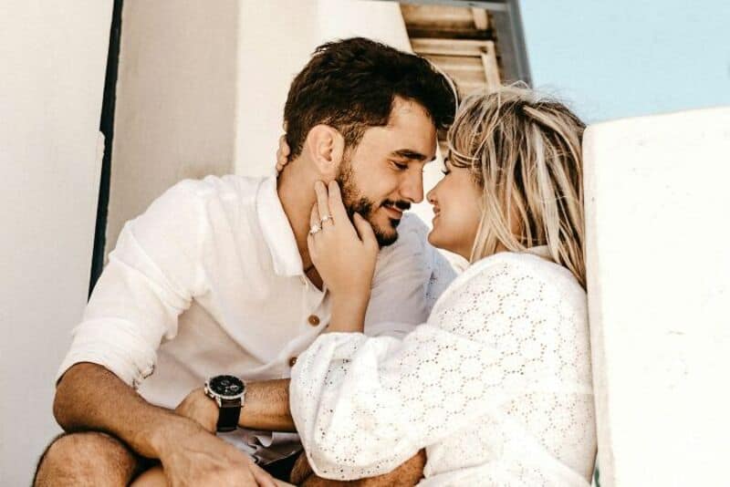 A couple touching foreheads and smiling at each other.