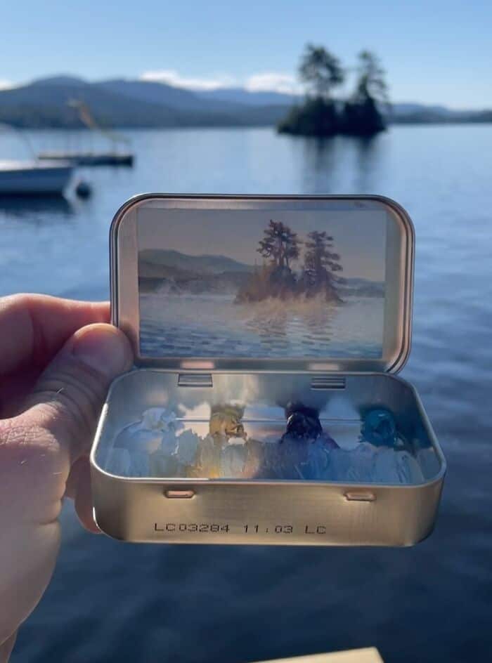 Scenic view of a small island with trees, seen through a phone screen over water.