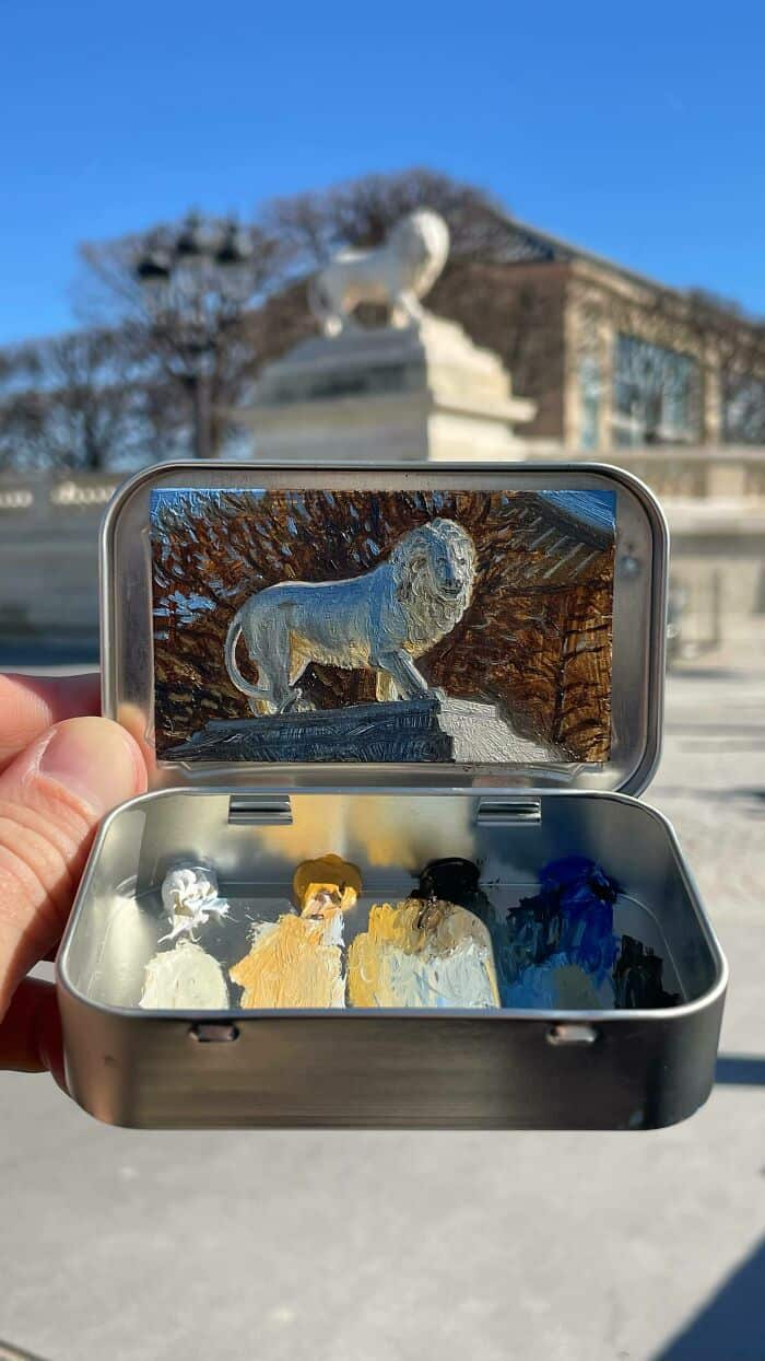 Small metal box with lion figurine and four small animal figures inside, outdoors.