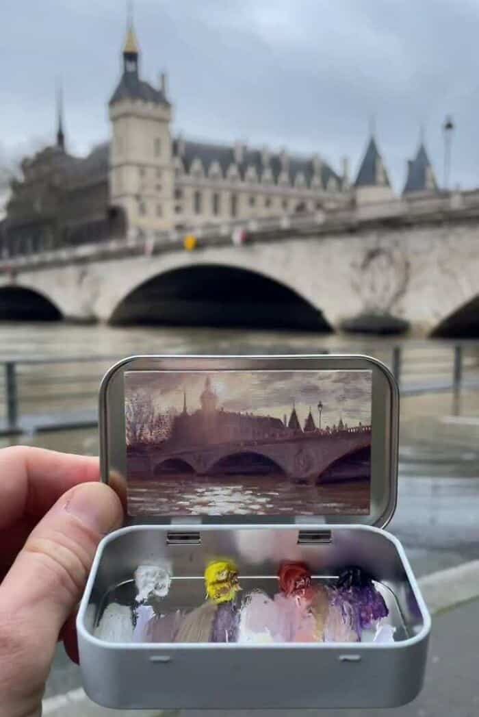 View of a historic bridge and castle reflected in a phone screen, with ice cream in the foreground.