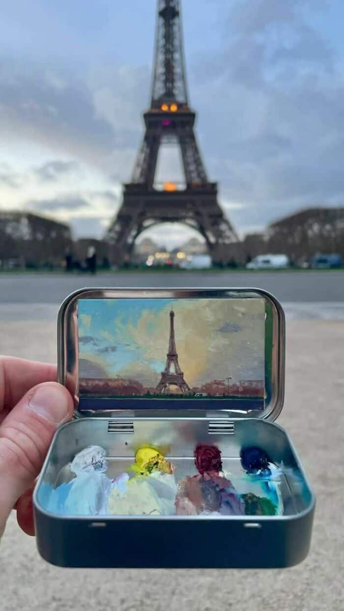 Eiffel Tower viewed through a smartphone with a painting of the tower inside a box.