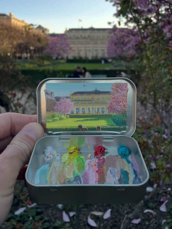 Miniature painting of the White House inside a metal case held outdoors.