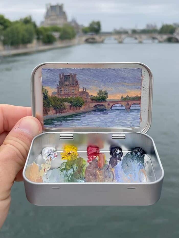Miniature painting of a river scene with a bridge and historic building in the background.