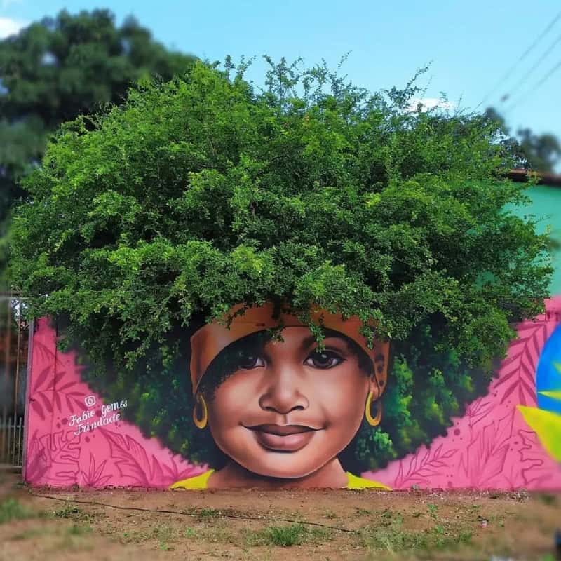 Vibrant mural of a girl with lush green hair and a warm smile.