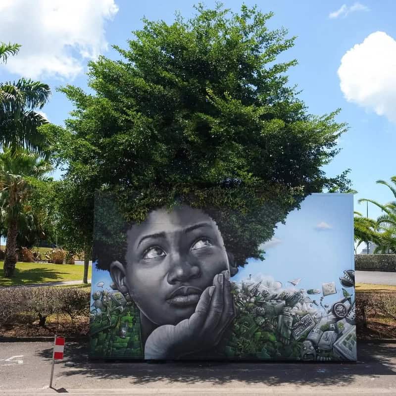 Large mural of a young girl with a tree as her hair, surrounded by various objects.