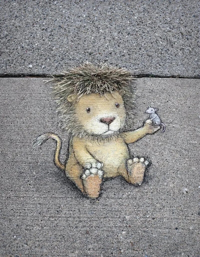 Cute lion drawing with a small mouse on its paw on a concrete wall.