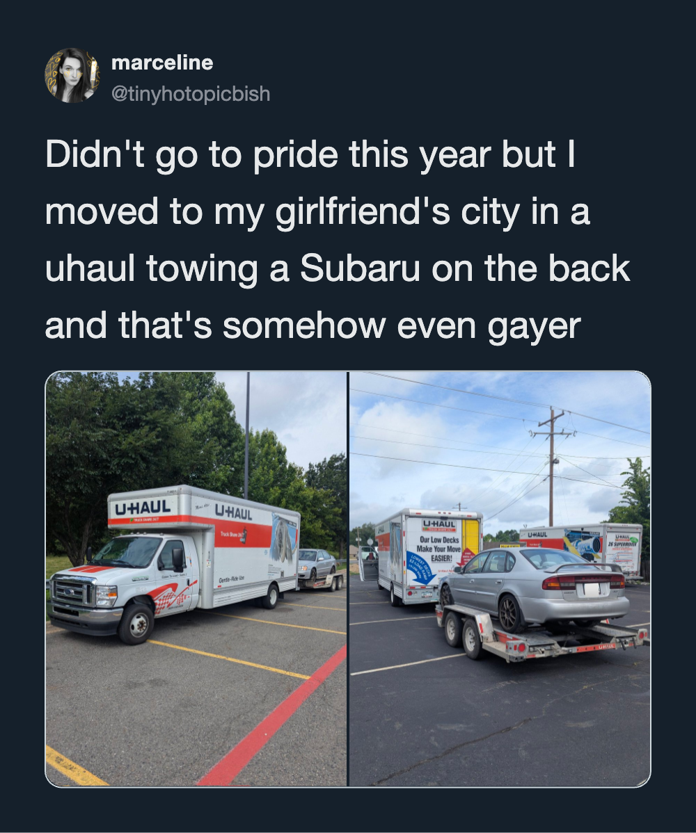 U-Haul truck towing a car in a parking lot, moving to girlfriend's city.