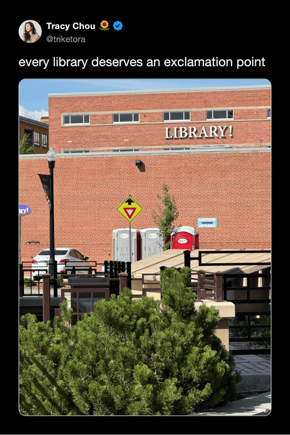 A library building with a brick facade and a sign that says "LIBRARY!".