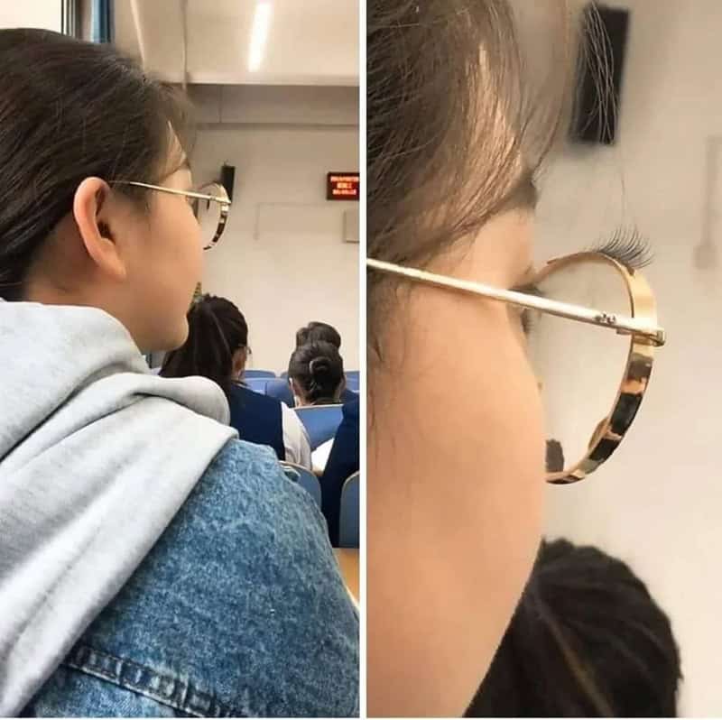 Woman with glasses sitting in an auditorium, side view, with a close-up of her face and glasses.